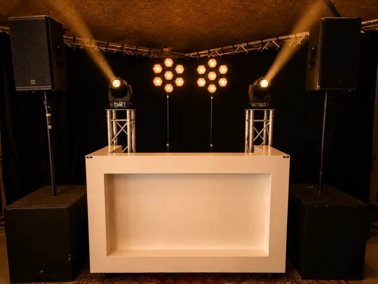 Witte DJ-booth met RCF KX-32A speakerset, retrolampen en twee moving heads op truss, te huur bij dre-events